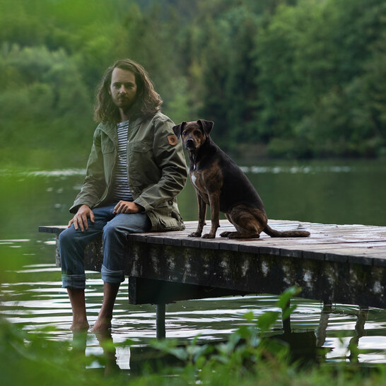 Beim Rückruftraining der Hundeschule Zamperlschickeria sitzen Halter und Hund auf einem Steg. | © Zamperlschickeria